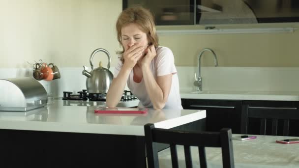 La mujer de la cocina usa la tableta, acaba de despertarse. El desayuno. Temprano. — Vídeo de stock