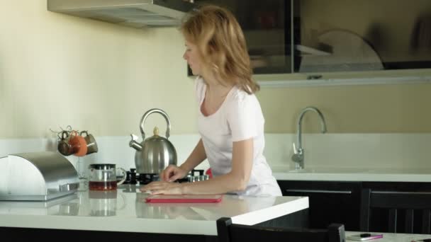 La femme dans la cuisine utilise la tablette, vient de se réveiller. Petit déjeuner. Tôt le matin — Video