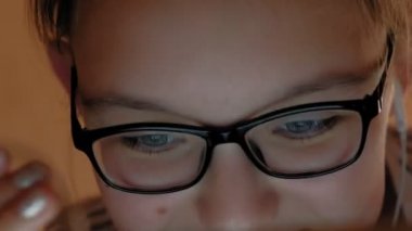 Genç kız kulaklıklı tablet kullanıyor. Akşam saati