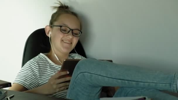 Teen Girl använder Tablet med hörlurar. Kvällstid — Stockvideo