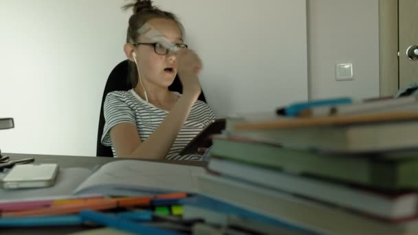 Tini lány használja tabletta fejhallgatóval. Esti idő — Stock videók