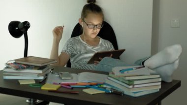 Genç kız kulaklıklı tablet kullanıyor. Akşam saati