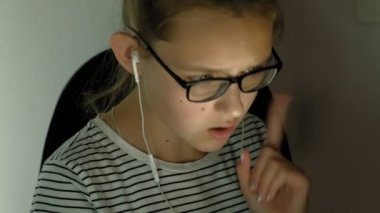 Genç kız kulaklıklı tablet kullanıyor. Akşam saati