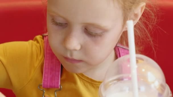 Una bambina mangia fast food. Cibo spazzatura. catena alimentare — Video Stock