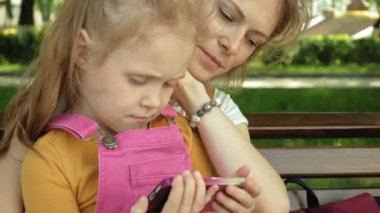 Anne ve kızı açık havada gadget'lar kullanın. Yaz