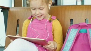 Okul öncesi kız kulaklık ve bilgisayar tablet açık kullanır. ışık gün saati