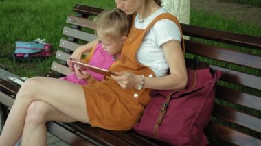 Anne ve kızı açık havada gadget'lar kullanın. Yaz