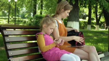 Anne ve kızı açık havada gadget'lar kullanın. Yaz