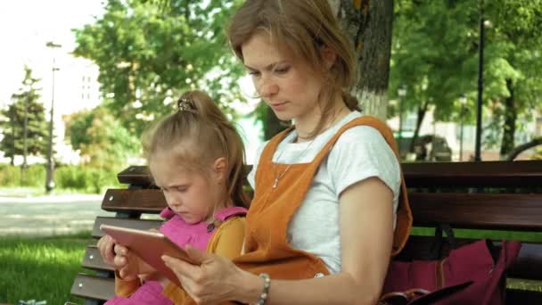Mutter und Tochter nutzen Geräte im Freien. Sommer — Stockvideo