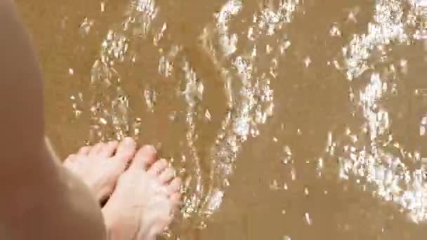 Los pies están en la arena cerca del agua. Playa. Día soleado de verano — Vídeos de Stock