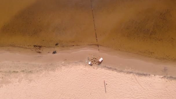 Mamma e figlia stanno giocando sulla spiaggia, costruendo un castello di sabbia. Giornata estiva di sole. vacanza. Sparatoria aerea — Video Stock