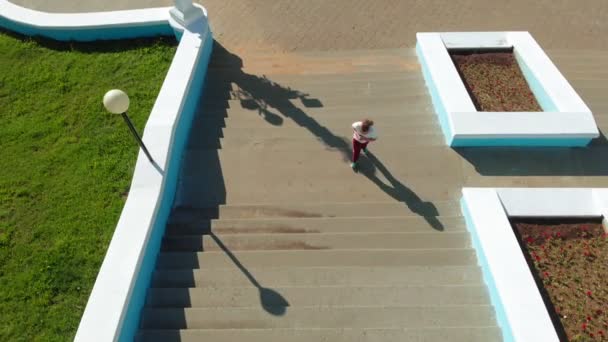 A adolescente sobe as escadas. Desporto. Tiro aéreo — Vídeo de Stock