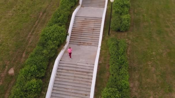 A adolescente sobe as escadas. Desporto. Tiro aéreo — Vídeo de Stock