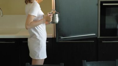 Genç bir kadın buzdolabını açar, ürünleri seçer. Sabah