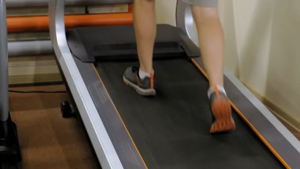 Sterke jonge man op de loopband in de sportschool — Stockvideo