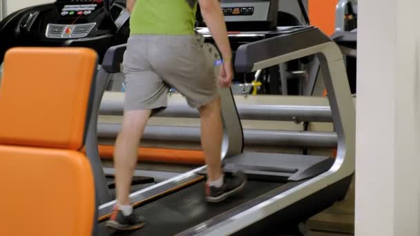 Mocny młody człowiek na bieżni w siłowni — Wideo stockowe