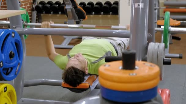 Man doet Bench Press in fitness studio — Stockvideo