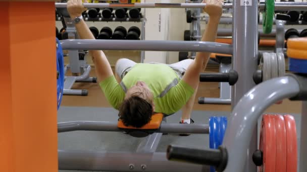 Mann macht Bankdrücken im Fitnessstudio — Stockvideo