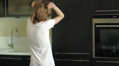 Genç bir kadın buzdolabını açar, ürünleri seçer. Sabah
