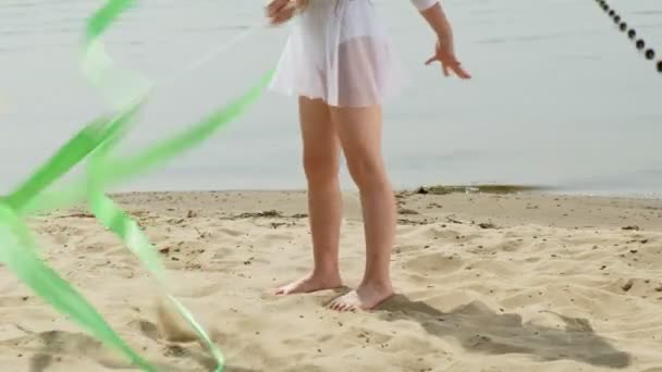 Préscolaire avec danse un ruban de gymnastique sur une plage de sable fin. Été, aube — Video