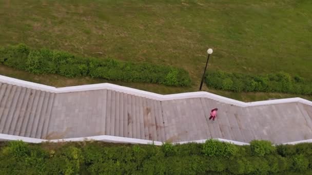 Une adolescente monte les escaliers. Du sport. Prise de vue aérienne — Video