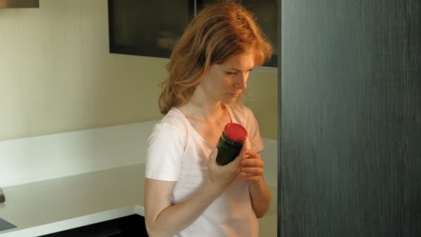 Μια νεαρή γυναίκα ανοίγει το ψυγείο, επιλέγει προϊόντα. Πρωί — Αρχείο Βίντεο