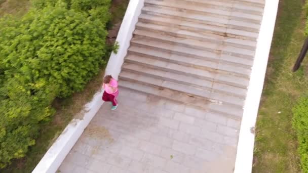 Девочка-подросток бежит вверх по лестнице. Спорт. Воздушная стрельба — стоковое видео