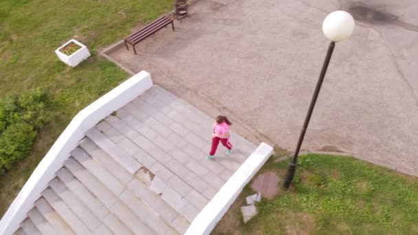 Chica adolescente corre por las escaleras. Deporte. Disparo aéreo — Vídeo de stock