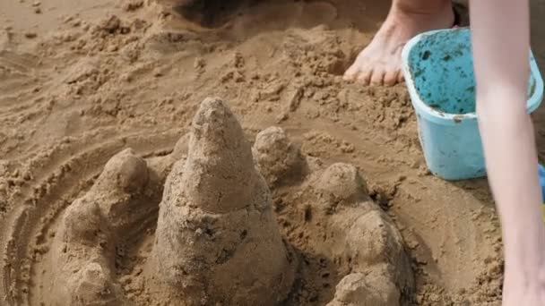 Mutter und Tochter spielen am Strand und bauen eine Sandburg. Sommersonniger Tag. Urlaub. Luftaufnahmen — Stockvideo