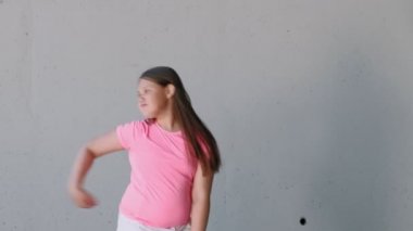 Gri bir arka plan üzerinde dans kız genç. Sokak dansı