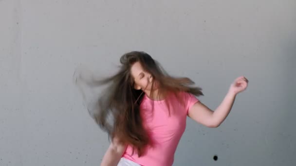 Dívčí teenager tančí na šedém pozadí. Pouliční tanec — Stock video