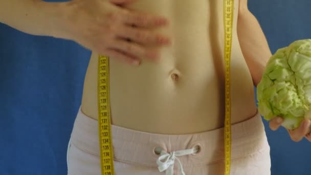 Kvinna med en platt mage. Närbild på en blå bakgrund. Hälsosam mat, fitness — Stockvideo