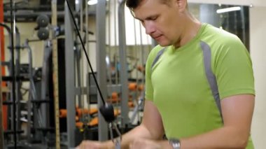 Spor salonunda triceps egzersizleri yapan adam