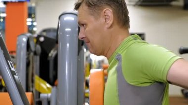  Adam bir fitness stüdyosunda simülatörde kelebek egzersizi yapıyor. Fitness ve Spor
