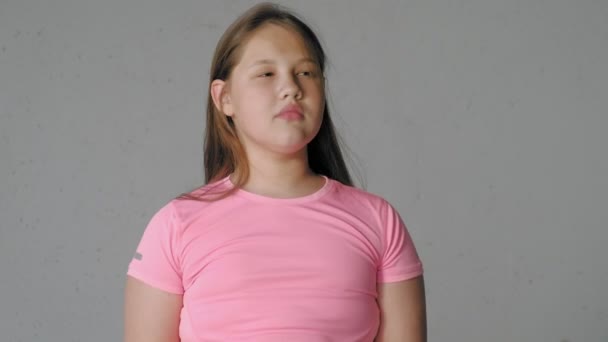 Meisje tiener op een grijze achtergrond beeldt emoties — Stockvideo