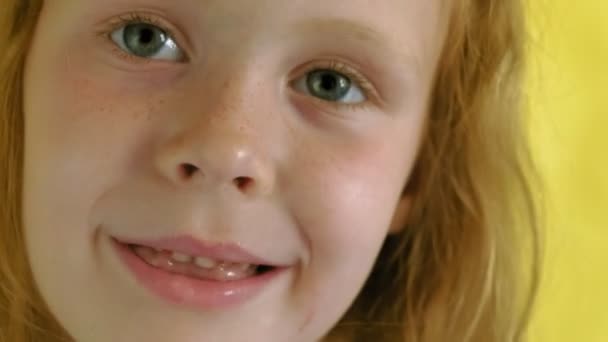Sarı arka planda lolipopu olan küçük bir kız. Portreyi kapat — Stok video