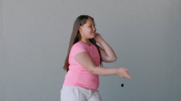 Κορίτσι έφηβος που χορεύει σε γκρίζο φόντο. Χορός του δρόμου — Αρχείο Βίντεο