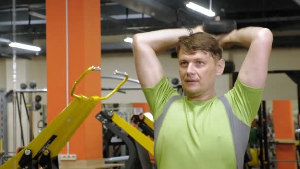 Man doet bankdrukken met dumbbells in fitness studio — Stockvideo