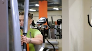  Adam bir fitness stüdyosunda simülatörde kelebek egzersizi yapıyor. Fitness ve Spor