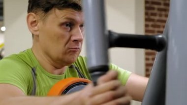  Adam bir fitness stüdyosunda simülatörde kelebek egzersizi yapıyor. Fitness ve Spor