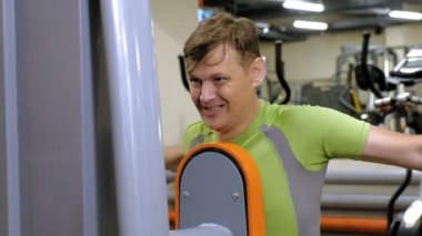  Adam bir fitness stüdyosunda simülatörde kelebek egzersizi yapıyor. Fitness ve Spor