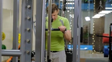 Spor salonunda triceps egzersizleri yapan adam