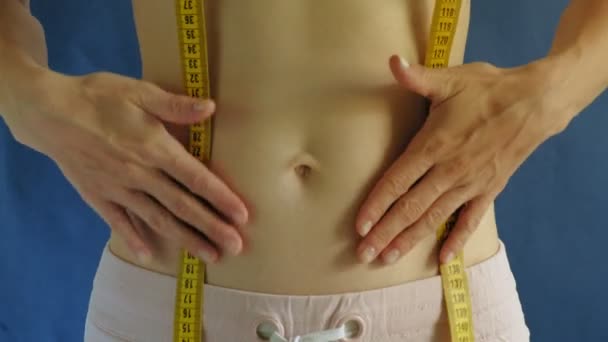 Kvinna med en platt mage. Närbild på en blå bakgrund. Hälsosam mat, fitness — Stockvideo