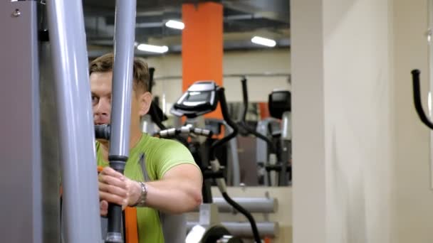 Muž dělá motýlka na simulátoru v fitness studiu. zdravý životní styl. Fitness a sport — Stock video