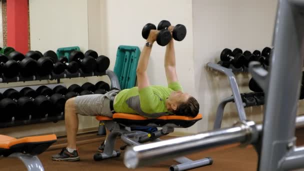 男子做板凳压与哑铃在健身工作室 — 图库视频影像