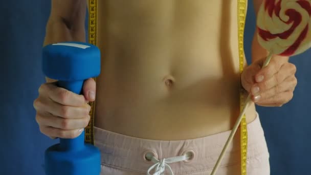 Mujer con el vientre plano. Primer plano sobre un fondo azul. Comida saludable, fitness — Vídeos de Stock