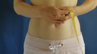 düz göbeği olan kadın. Mavi arka plan da yakın çekim. Sağlıklı gıda, fitness