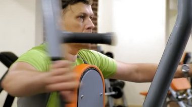  Adam bir fitness stüdyosunda simülatörde kelebek egzersizi yapıyor. Fitness ve Spor