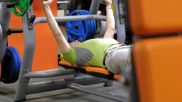 Hombre haciendo press de banca en gimnasio — Vídeo de stock