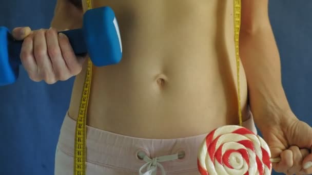 Kobieta z płaskim brzuchu. Zbliżenie na niebieskim tle. Zdrowa żywność, fitness — Wideo stockowe